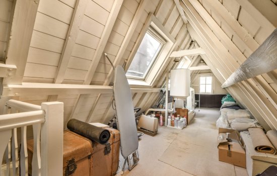an attic with wood sidings on the walls and flooring boards all over the entire space, as well