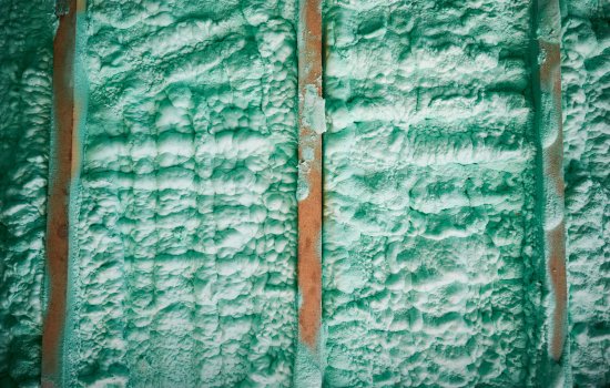 Cropped view of wall in wooden frame house thermal insulated by polyurethane foam. Construction and insulation concept.