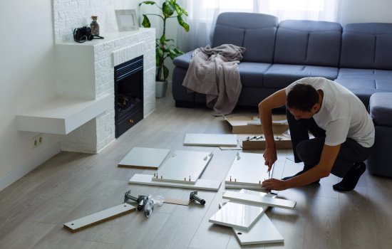 young man putting self assembly furniture as they move into your new house.